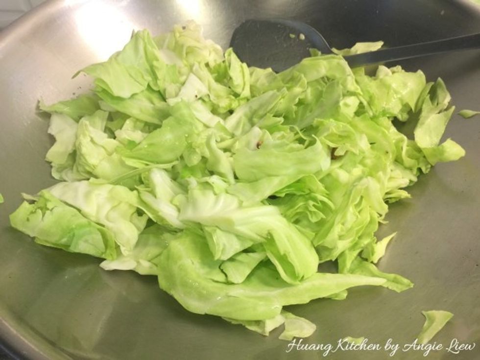Add in the thick slices of green cabbage and stir fry till the cabbage has slightly softened.