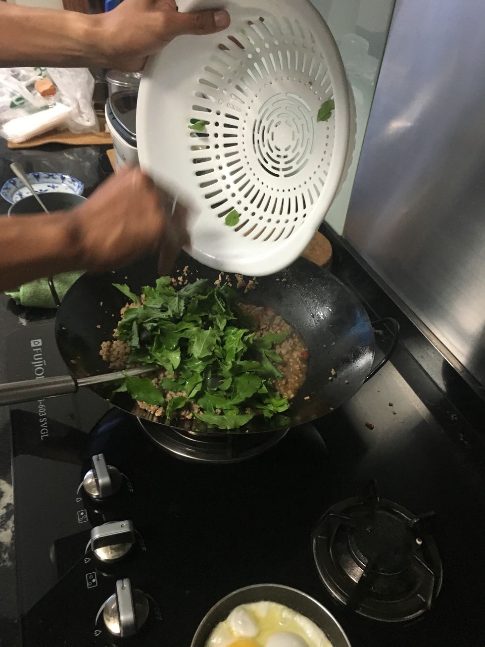 Add in your basil leaves. And continue to give it a good fry.