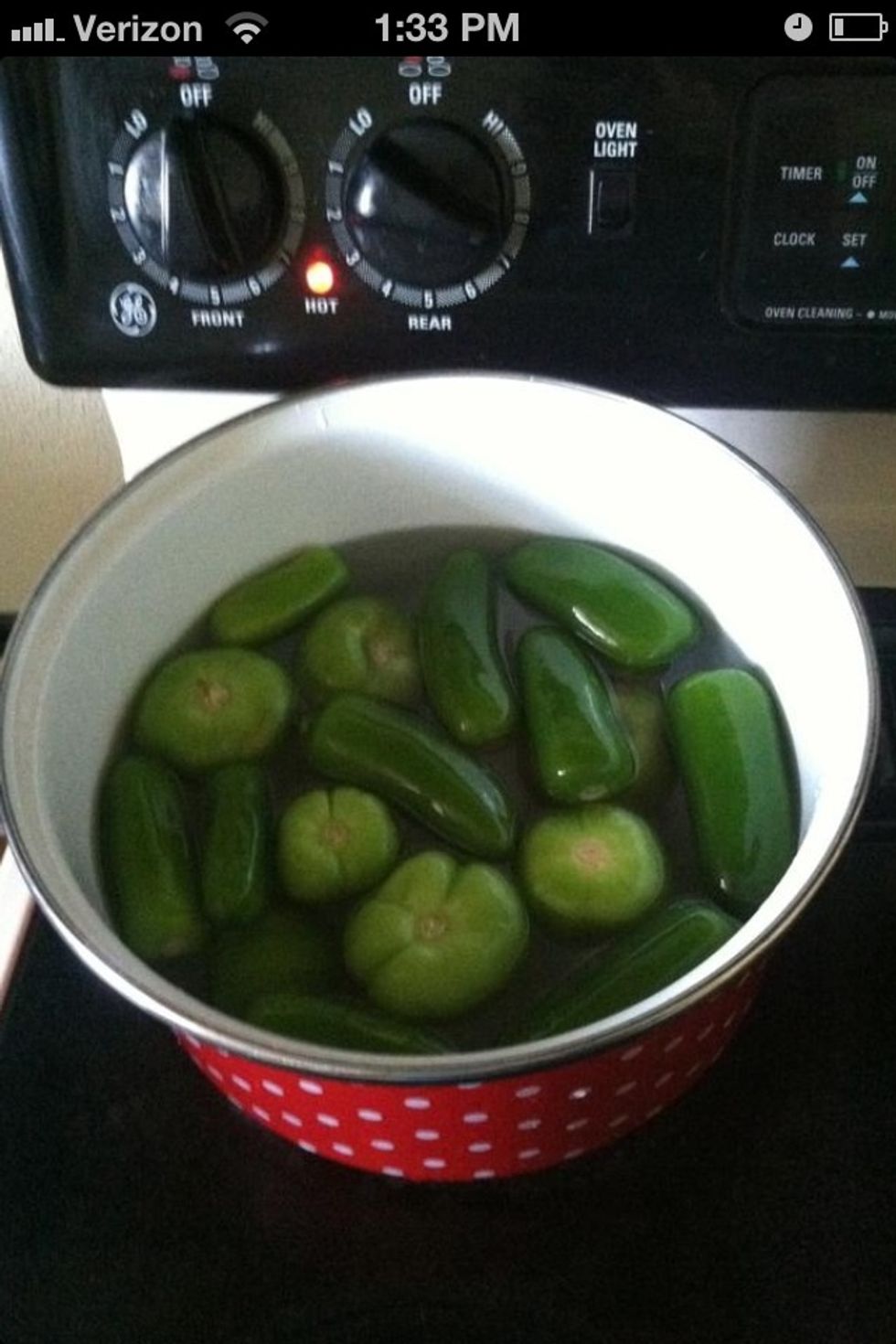 Add jalape\u00f1os and tomatillo in to a sauce pan with water. Put over med heat.