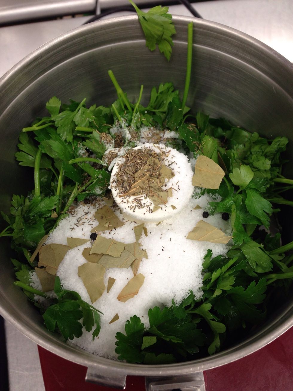 Add Kosher salt, parsley, broken bay leaves, thyme, and peppercorns to a food processor.