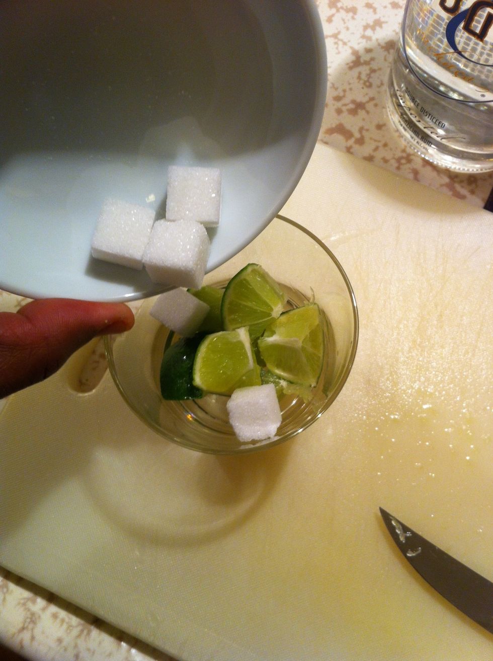 Add lime and sugar to your glass. I'm using 5 cubes but use 6 if you like it sweeter.