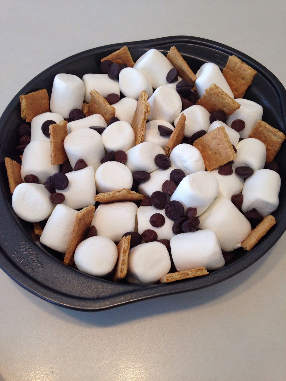 Add marshmallows, chocolate chips and broken graham crackers to pan.