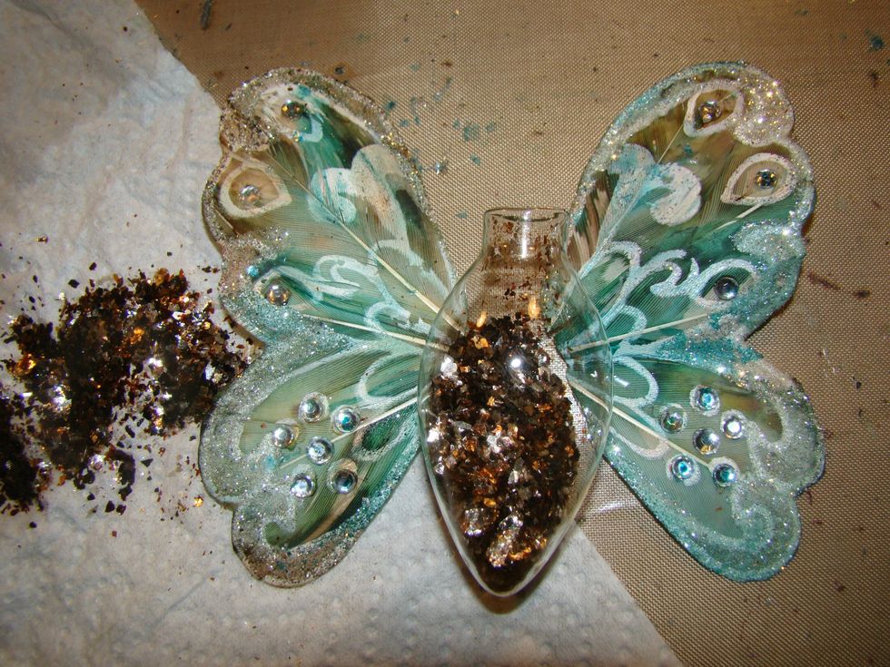 Add mica flakes to the light bulb ornament and attach your wings using a glue gun.