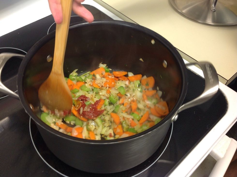 Add minced garlic and tomato paste.