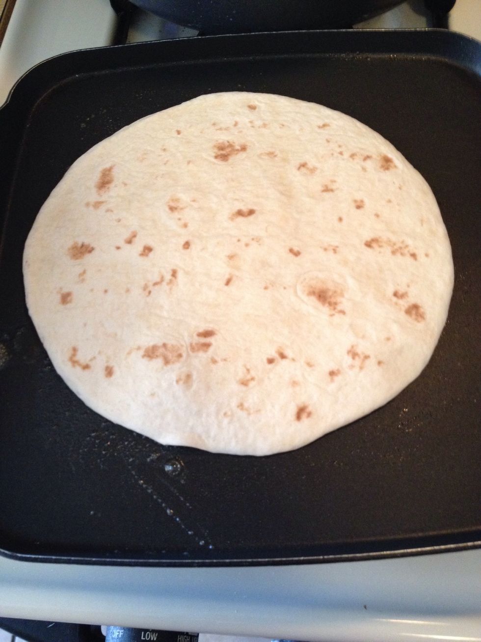 Add more butter then place one tortilla on skillet