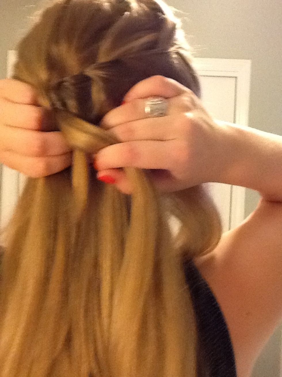 Add more hair to the left section of hair and cross it over so it becomes the middle section.