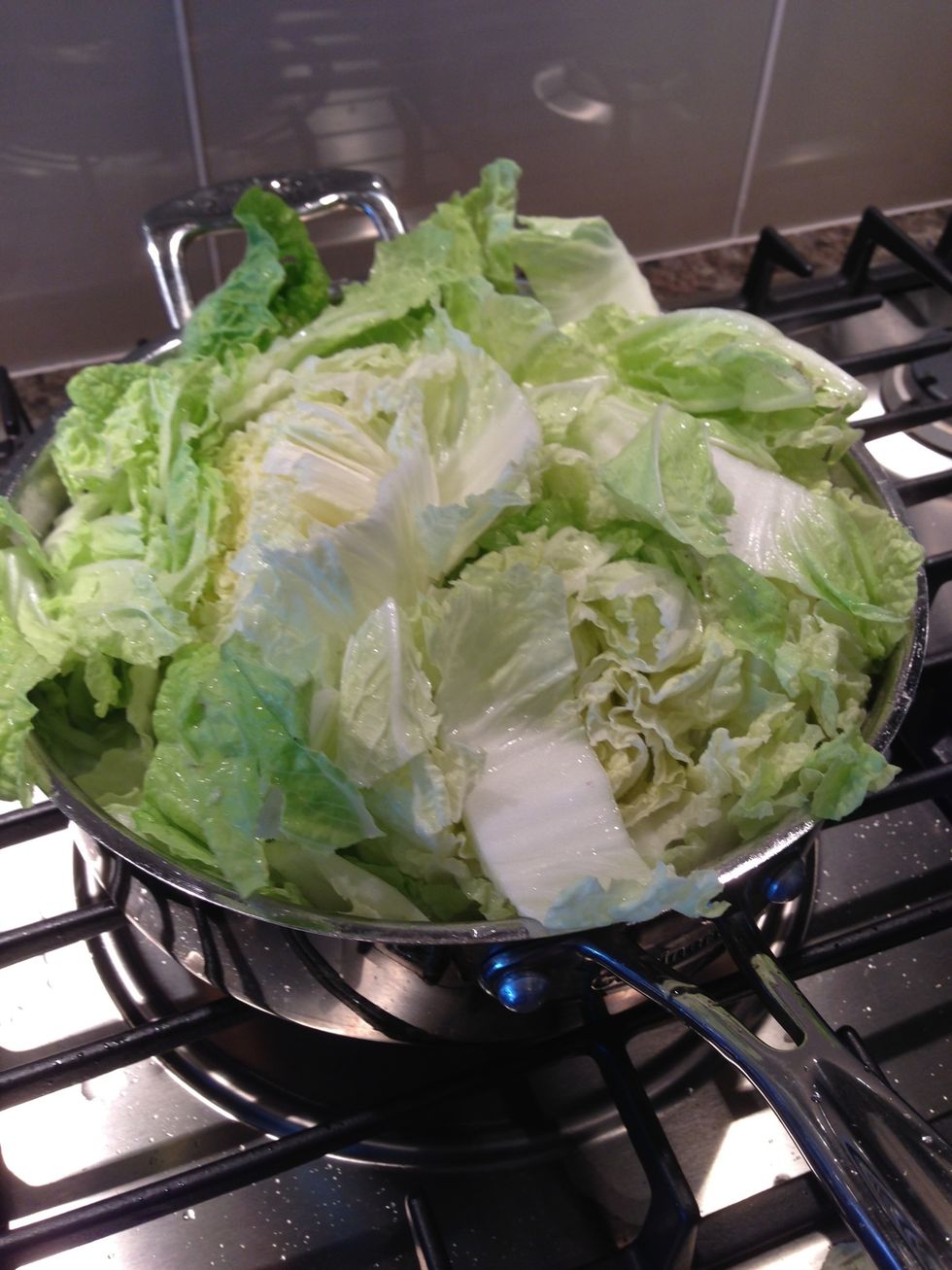Add napa, starting with hard parts. Cover the pan with a lid. Add ~1/4 cup water to help it along