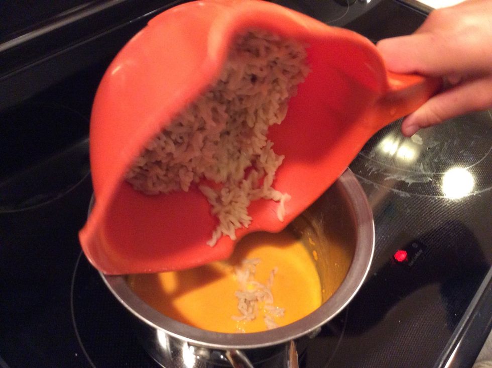 Add noodles to cheese sauce.