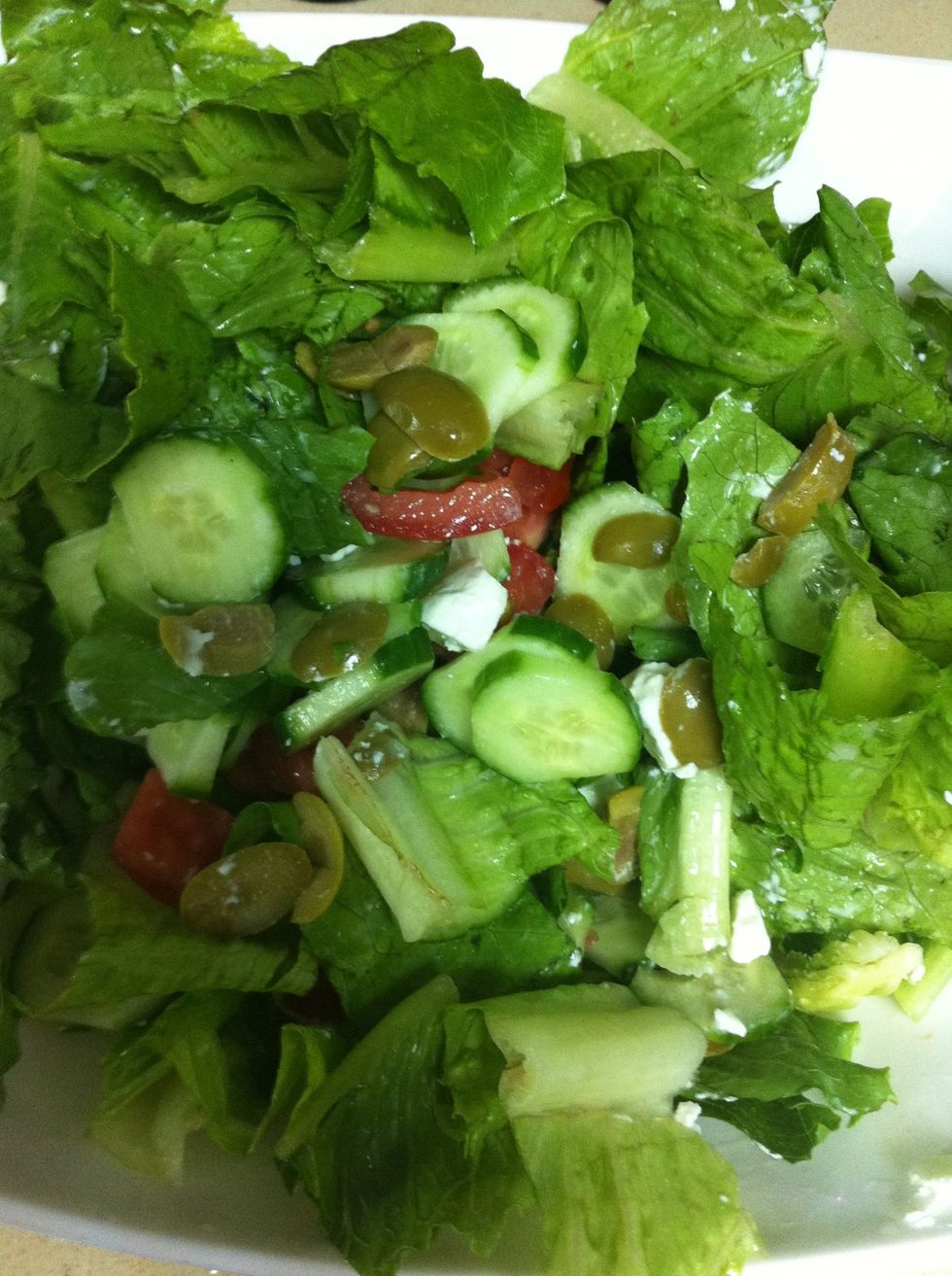 Add olives. If the olive is without pit add them without cutting them but if it's not so you have to take the pit out. And then cut the feta cheese in cube shape and add to the salad.