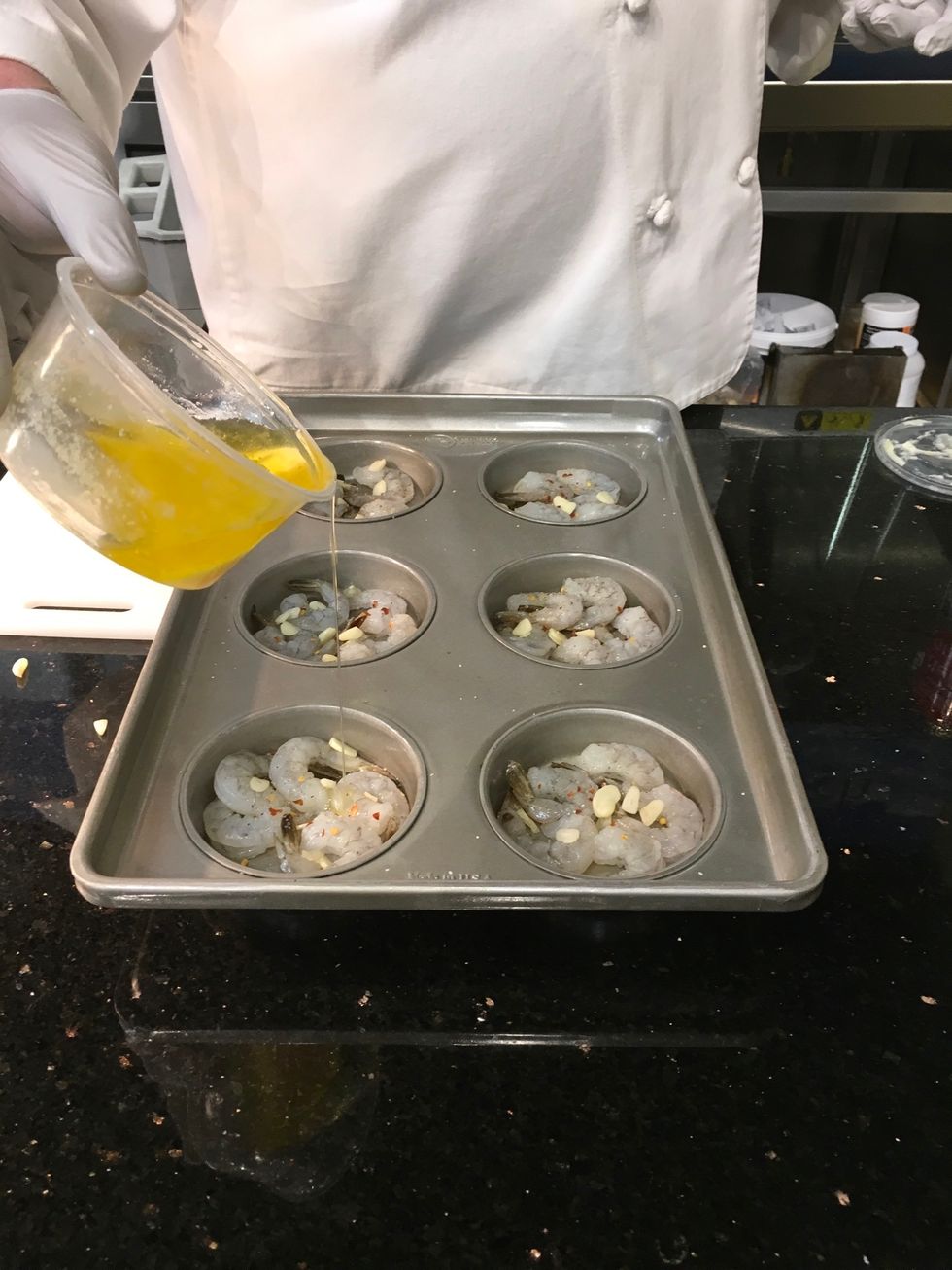 Add one clove of sliced garlic to each section of the pan (6 sliced cloves total). Add 1 teaspoon of butter to each section of the pan.