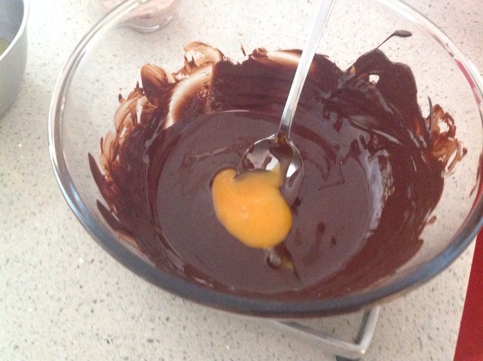 Add one egg yolk to the dark chocolate and stir until combined. The mixture will become firm.