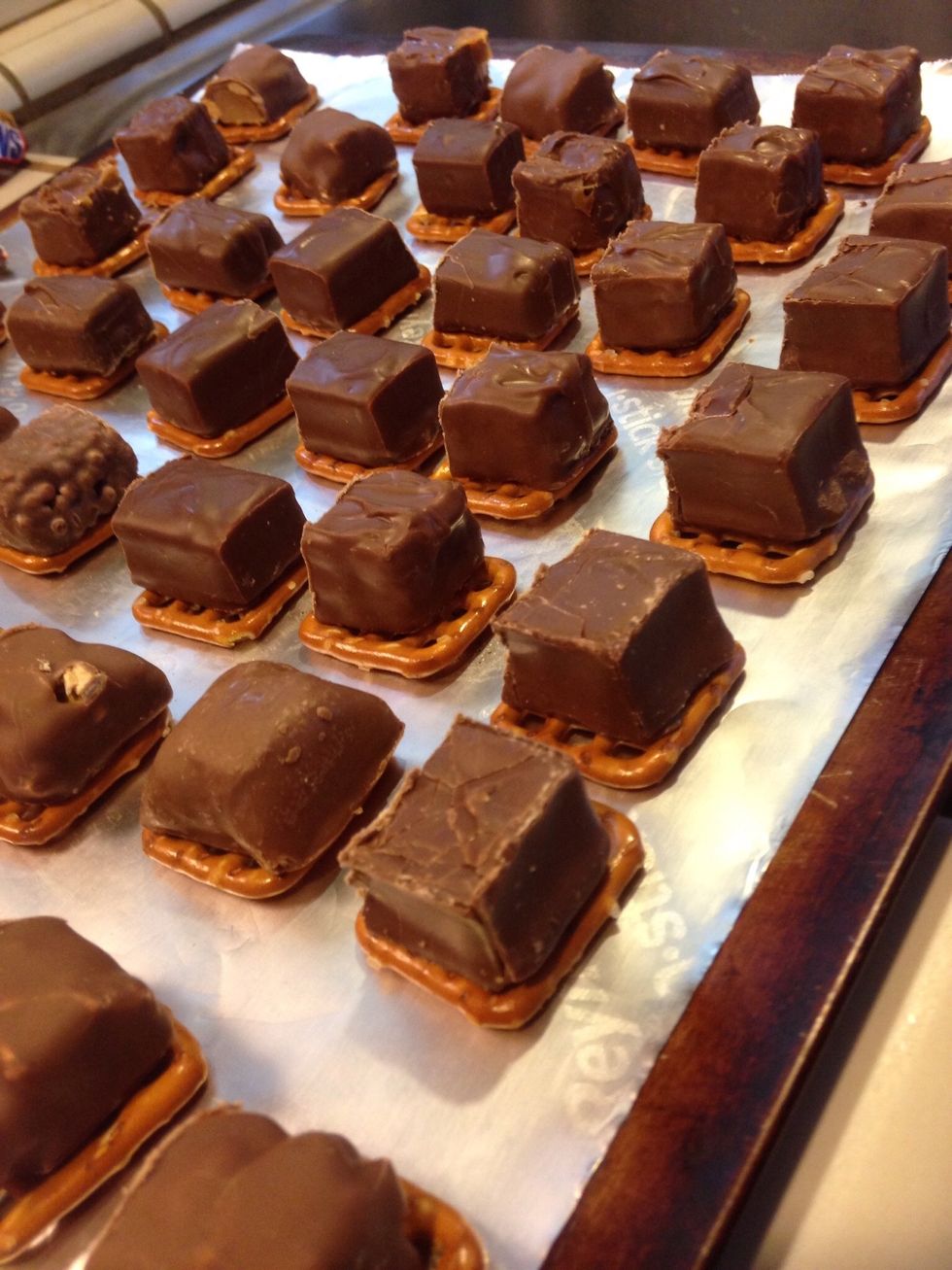 Add one mini chocolate bar to each pretzel. Bake in oven for 5 minutes to soften chocolate.