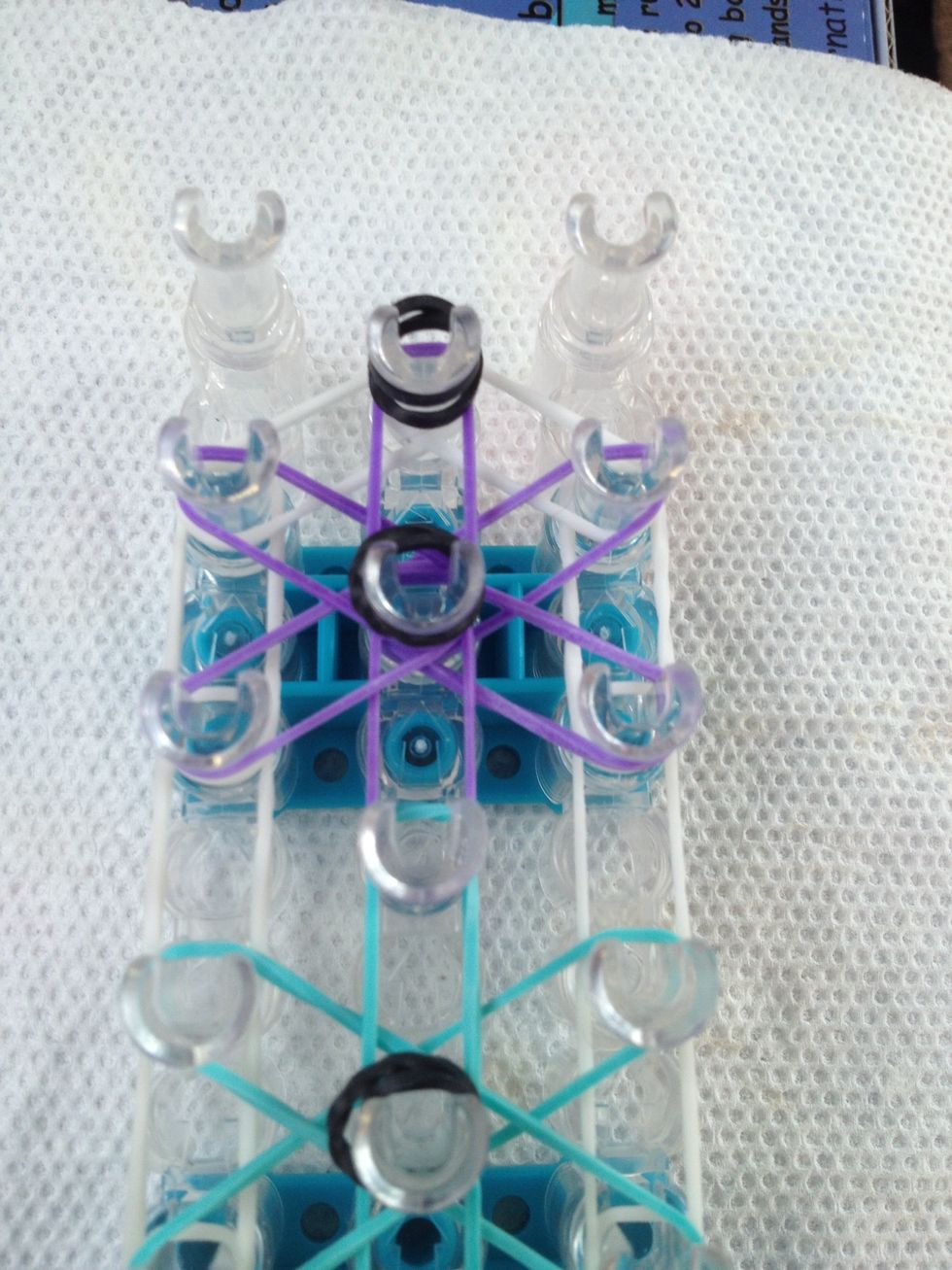 Add one more cap band on the last peg of the middle row of pegs.