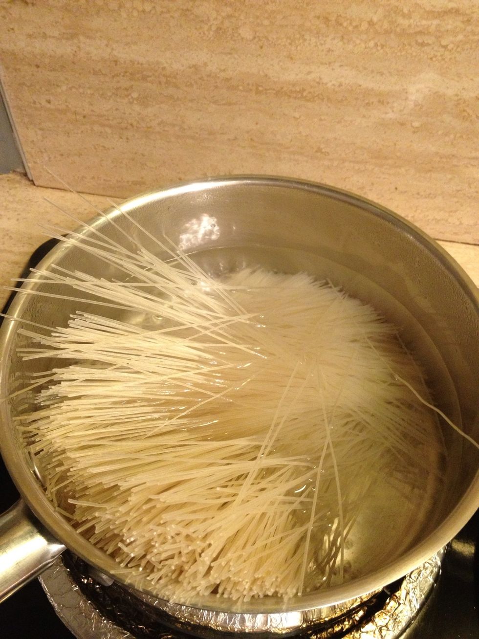 Add one package thin rice vermicelli noodles to boiling water then stir and lower heat to medium high.
