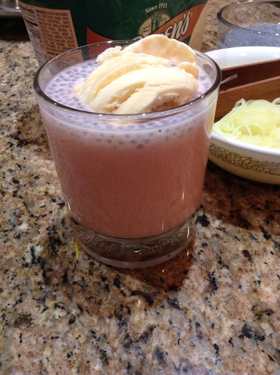 Add one scoop of vanilla ice cream to each of the four glasses.