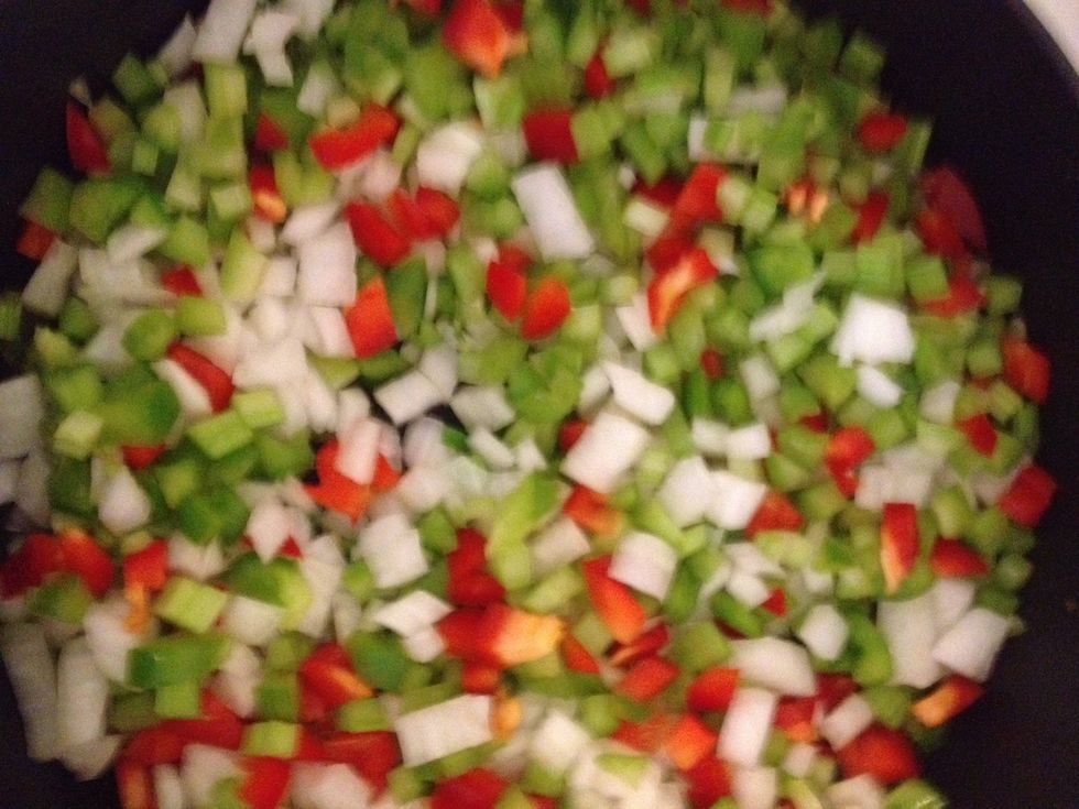 Add onions, celery, and bell peppers after a few minutes.