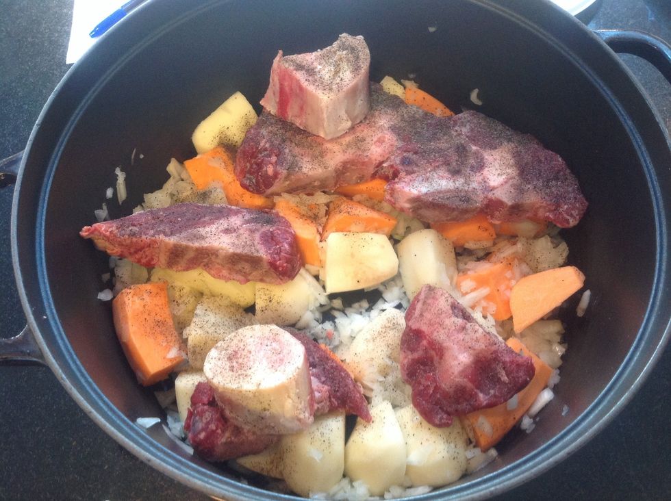 Add onions, (saut\u00e9ed if desired), quartered potatoes, sweet potato if you're adventurous, then meat and marrow bones, sprinkle salt and pepper
