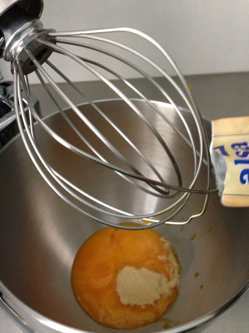 Add over the yolks. AND,  Immediately start your mixer. Never add sugar to eggs and let it stand .  Sugar will cook the eggs and the result is not the same