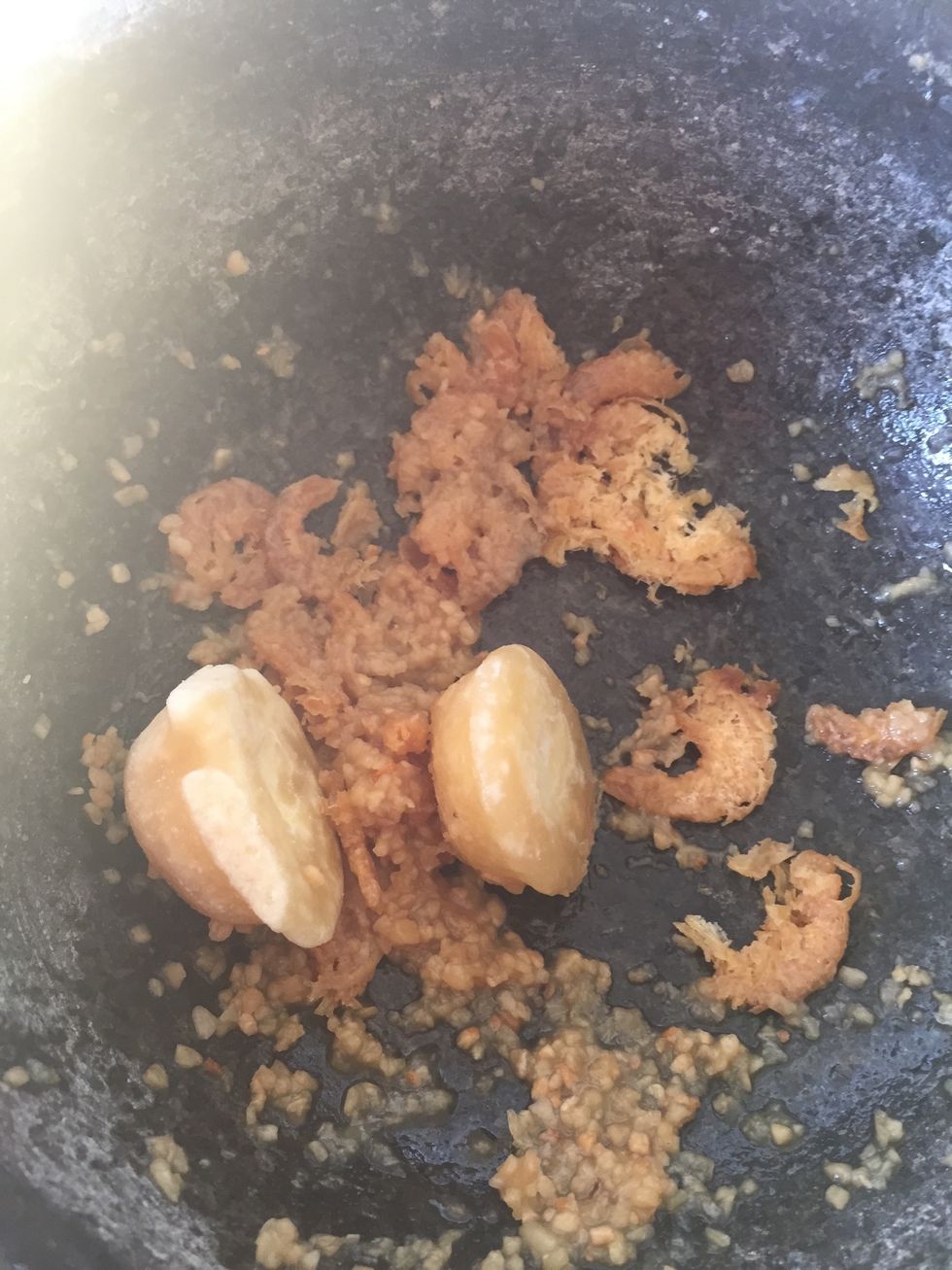 Add palm sugar and continue to pound until it's broken into small pieces.