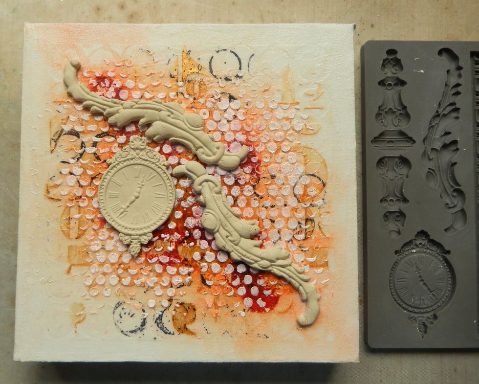 Add Paper Clay moulded elements onto the canvas over the inky areas. Paint them with white gesso once dry and add a little of the Gold Embossing Paste as a highlight.