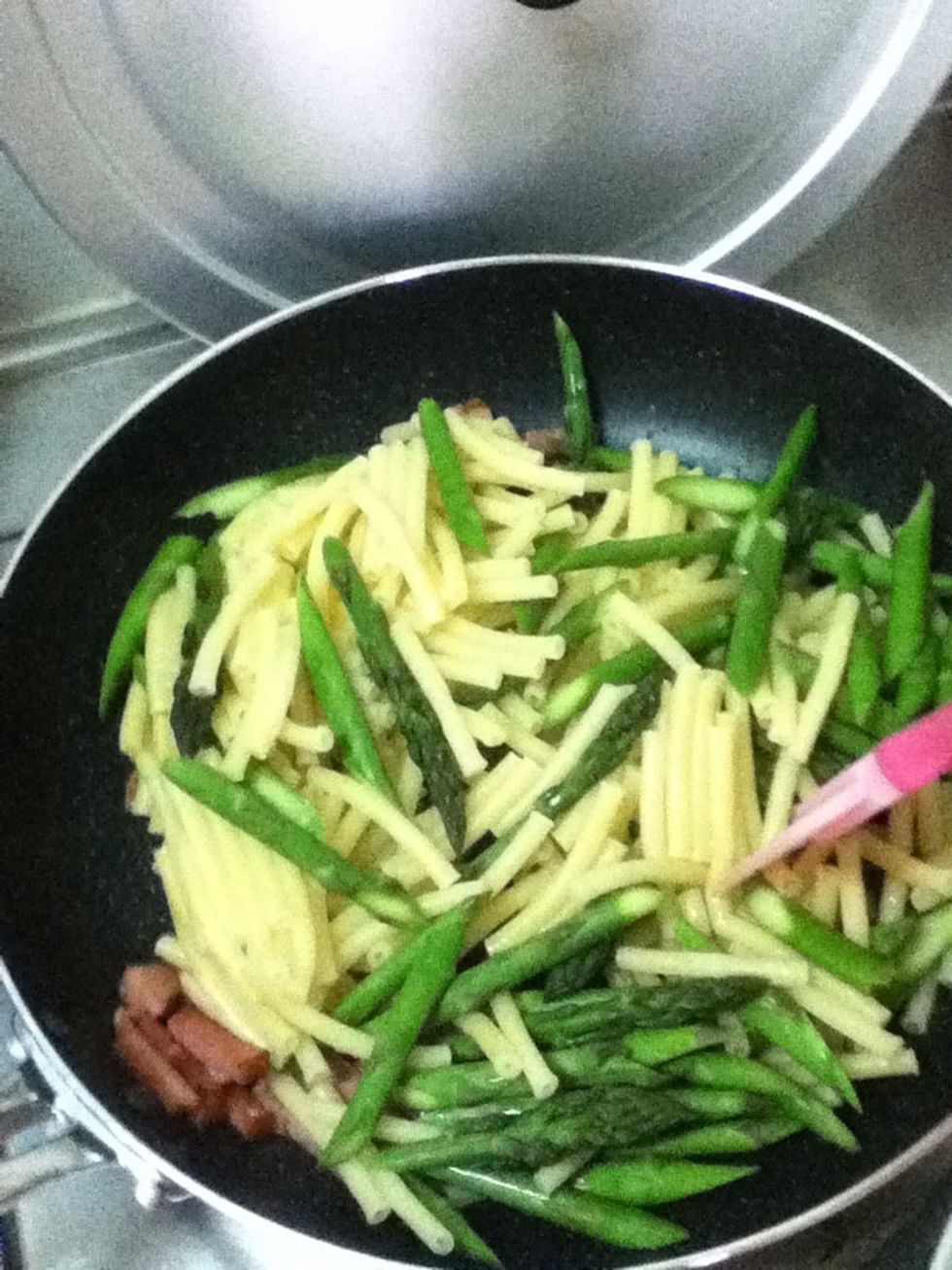 Add pasta and asparagus in the pan and saut\u00e9 for a min to mix together.
