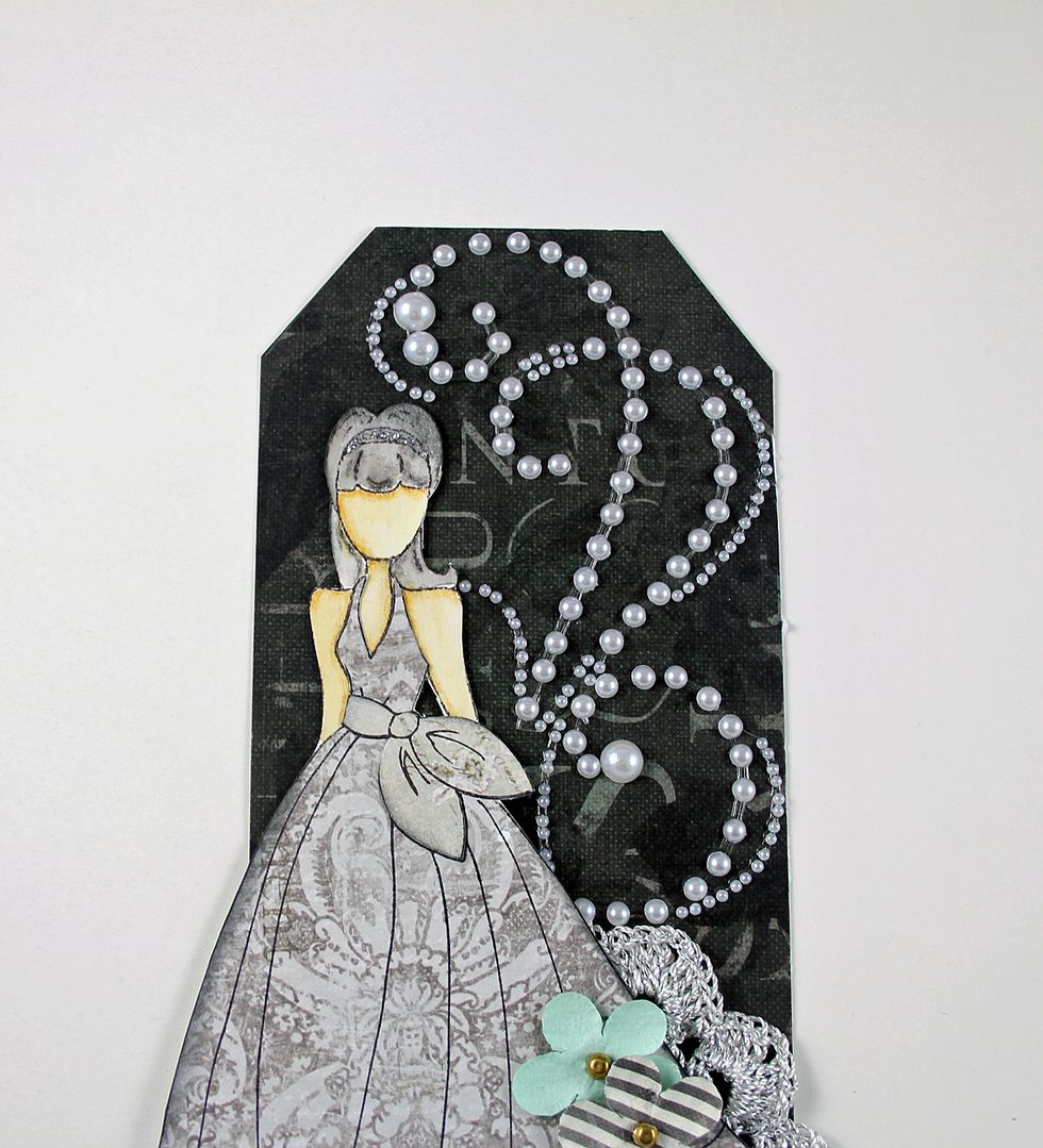 Add pearls to the right of the doll. You can cut the pearl swirl to fit the tag.