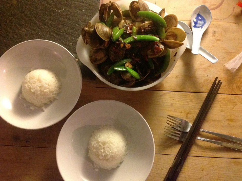 Add peas when clam shells are open and cook, covered for 2 min. Serve with rice