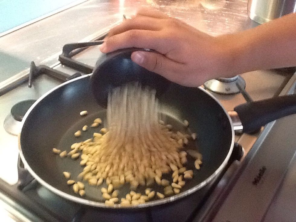 Add pine nuts into pan over medium heat