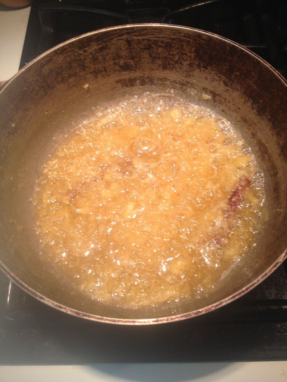 Add pineapple pulp and equal parts white sugar to a pot and let simmer at a low heat. Also add cinnamon sticks at this point. Stir until jam consistency.
