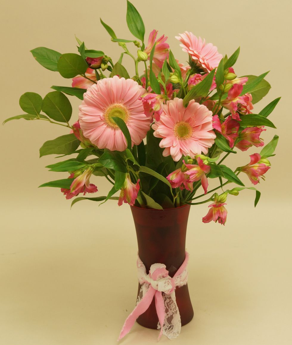 Add pink alstroemeria into arrangement.