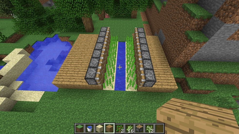 Add Pistons on the wooden planks closest to the Sugar Cane as shown in the picture.
