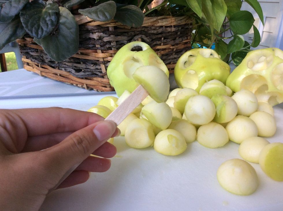 Add Popsicle stick into apple pieces