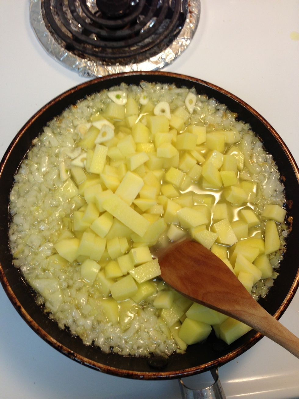 Add potatoes and the garlic when the onion is almost made (soft and transparent)