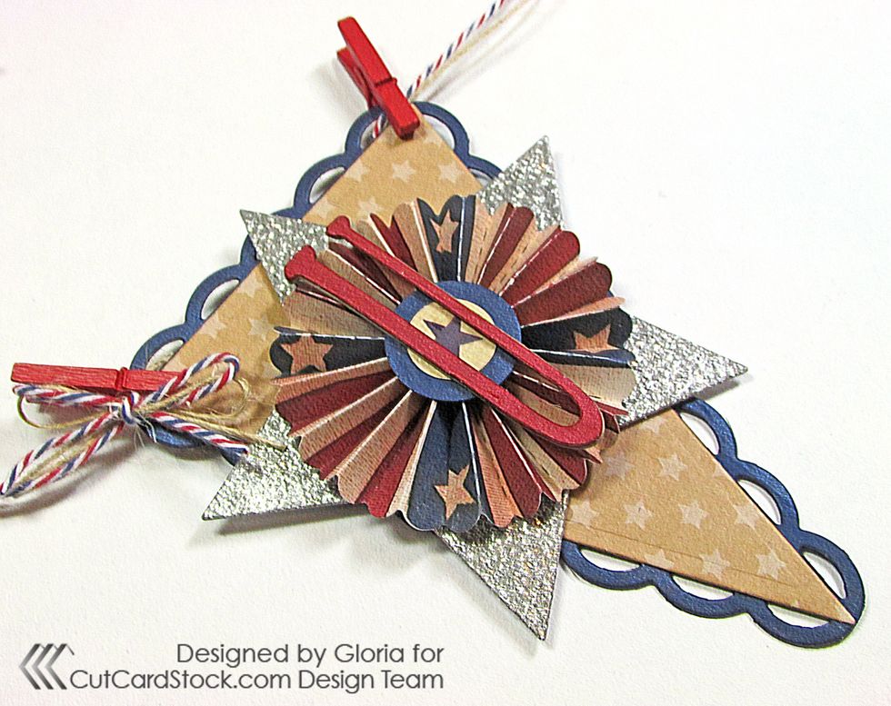 Add red clothespins to the "U" pennant. Tie a tiny bow with twine and glue it to the left corner of the pennant.