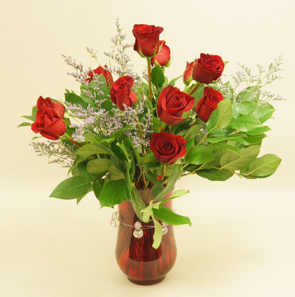 Add red roses and limonium into vase.