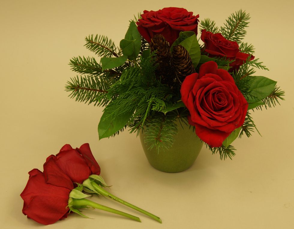 Add red roses to the arrangement.
