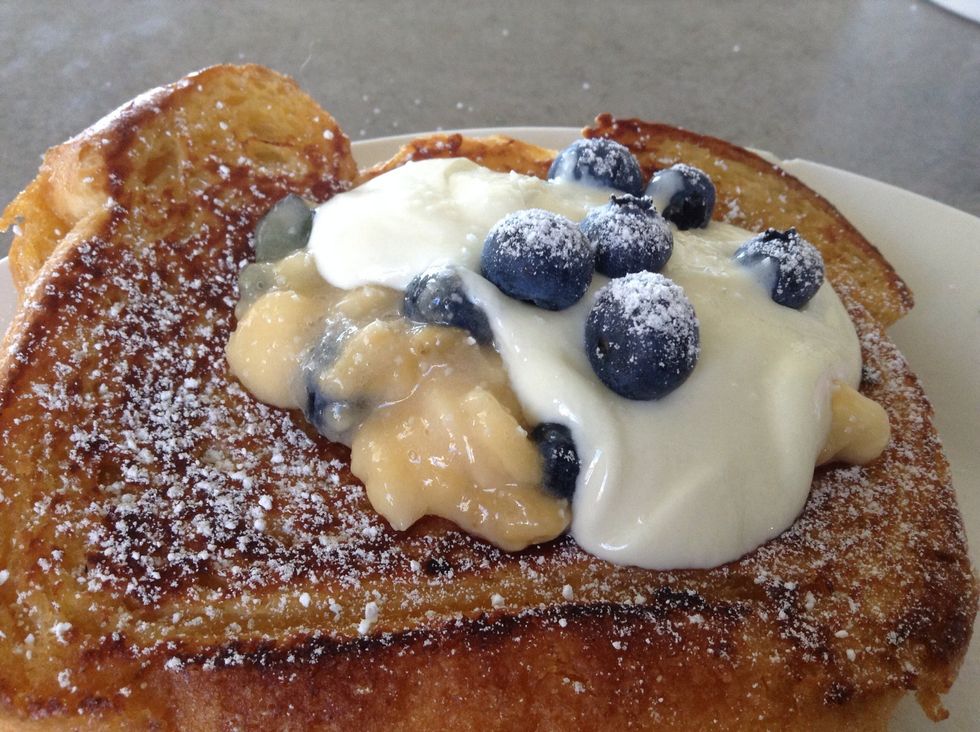 Add remaining banana/blueberry mixture on top with a dollop of Greek yogurt or creme fraiche and then dust with icing sugar when done on both sides
