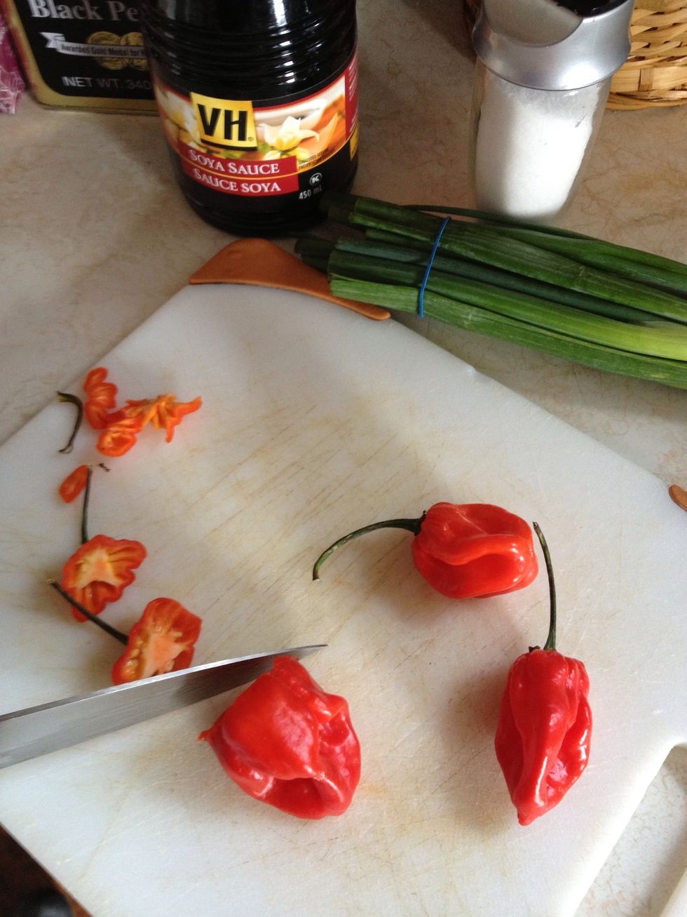 Add scotch bonnet peppers. Be careful not to get liquids on your hands or eyes! Wash hands after handling.