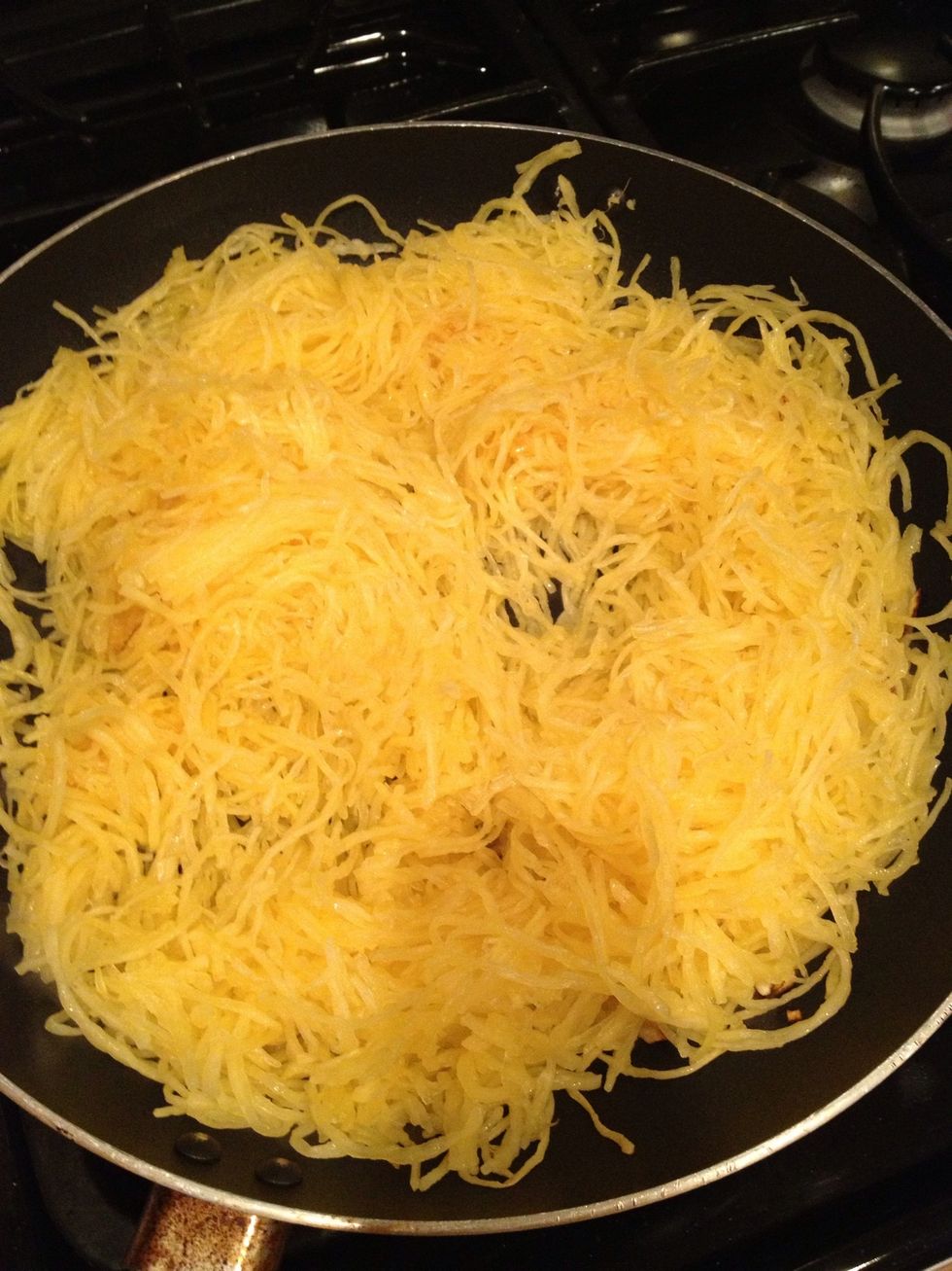 Add shredded spaghetti squash to your Saut\u00e9ed garlic and olive oil. Cook for 2 to 3 minutes.