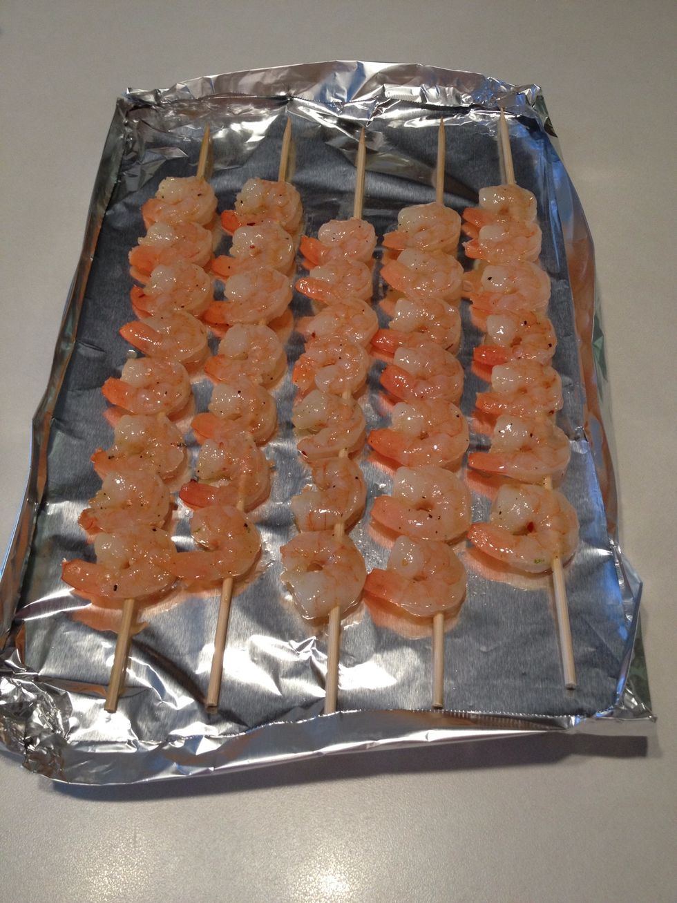 Add shrimp to skewers and place on aluminum foil.