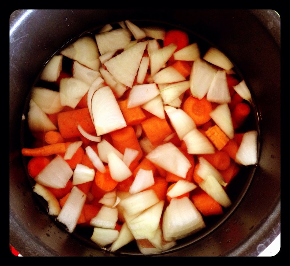 Add six cups water, chopped carrots, and chopped onion into a large pot.