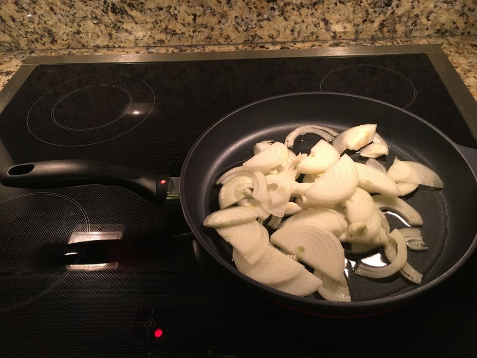 Add sliced onions and a dash of salt to the skillet.