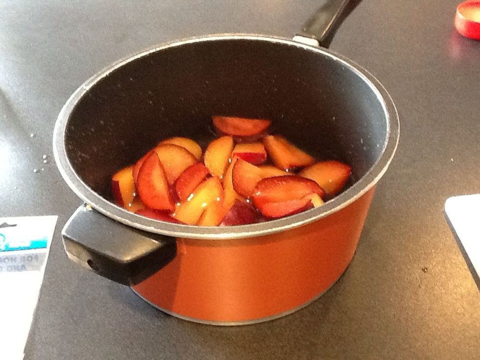Add sliced plums with the water from the jug into a pan