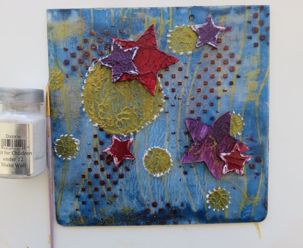 Add small dots of Dazzle Sorbet paint around the circles and over the stars. You can use the needle tool, the thin paint brush or even your fingers. Glue the stars around the page.