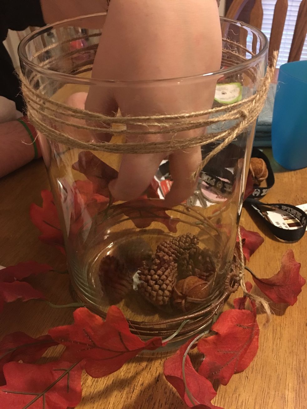 Add small floral pine cones into the bottom of the vase.