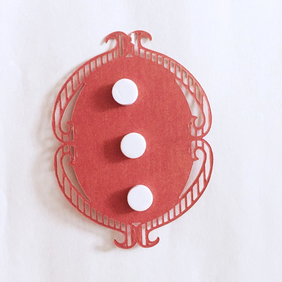 Add some foam dots at the back of the oval ornate piece. This will be the inner centerpiece of the candle cover.