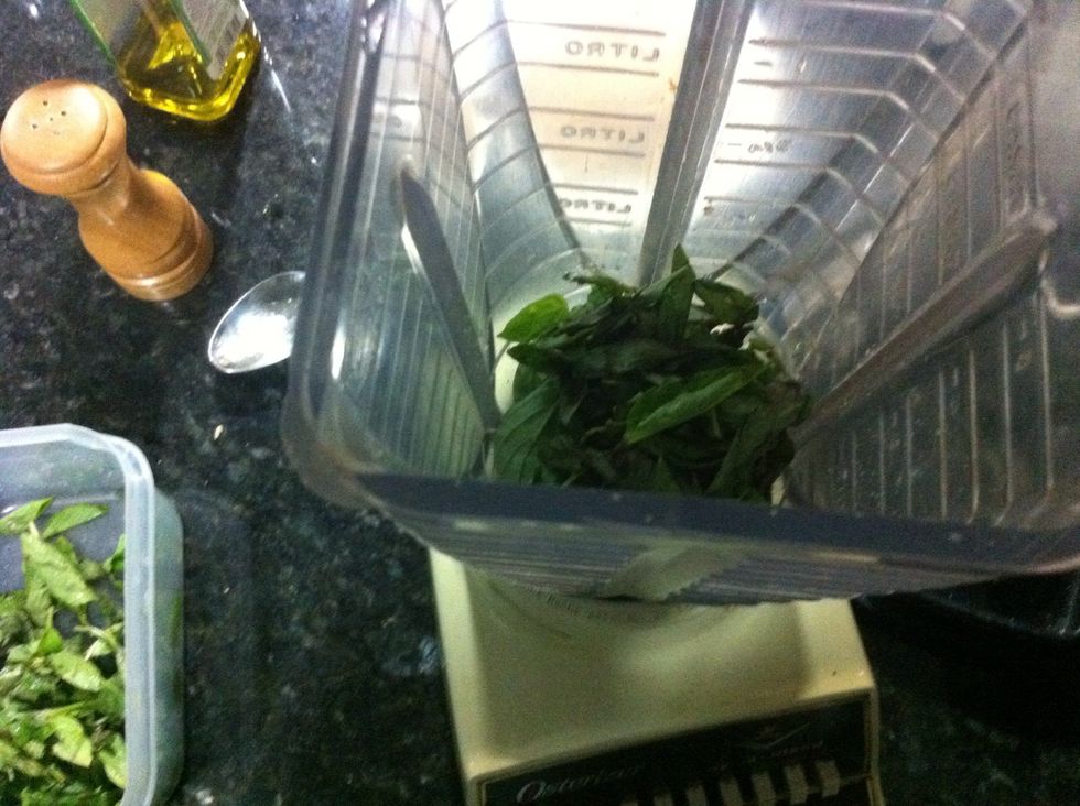 Add some of the basil leaves to the food processor...