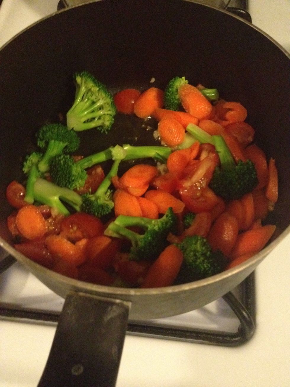 Add some oil then add garlic cook till brown. Add tomatoes, carrot and broccoli simmer for few minutes with small heat.