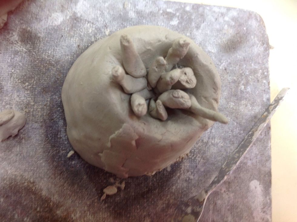 Add some pieces of clay out of the top of the volcano