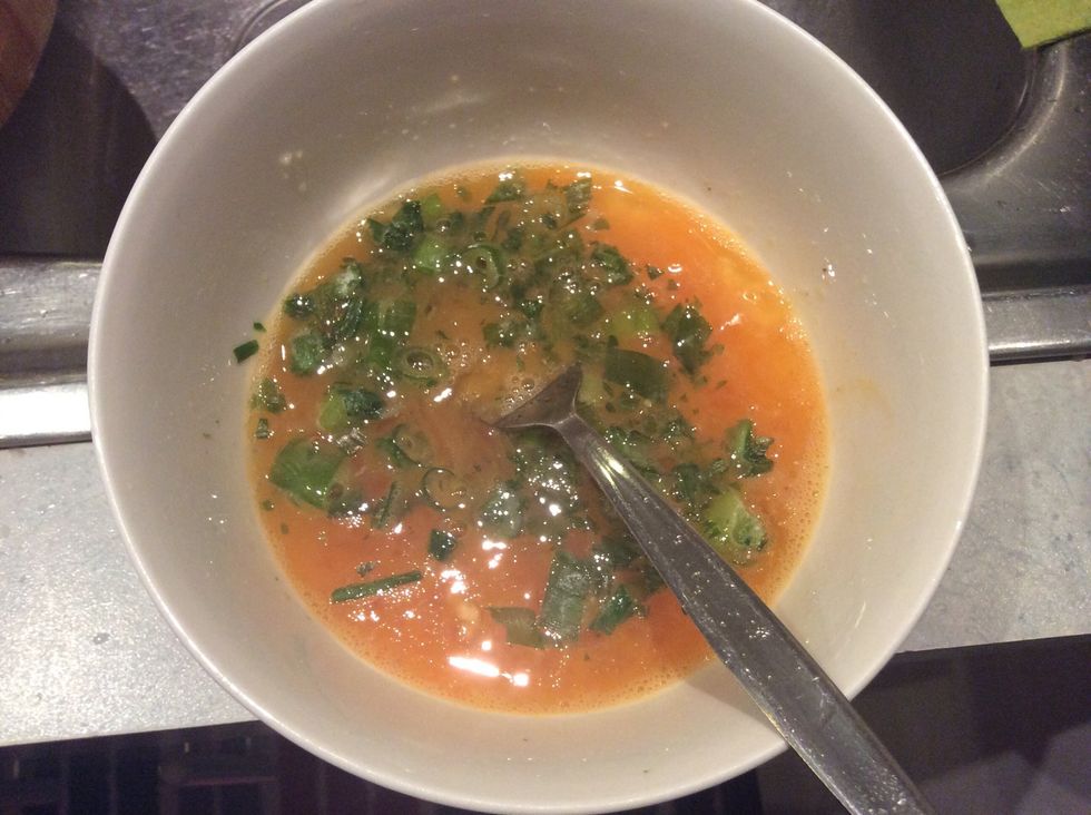 Add some spring onions into the egg also put a little bit of sugar, pepper and soy sauce into the egg mixture you made earlier and stir it a little bit